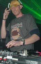 DJ Natural Nate® in Megadeth shirt at the mixer under green stage lighting